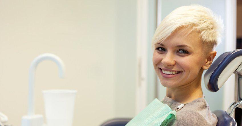 How to overcome dental phobia Blonde smiling woman sitting at the dentist and looking towards the camera